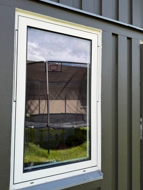Samma fönster efter putsning – klart, rent glas med tydlig spegling